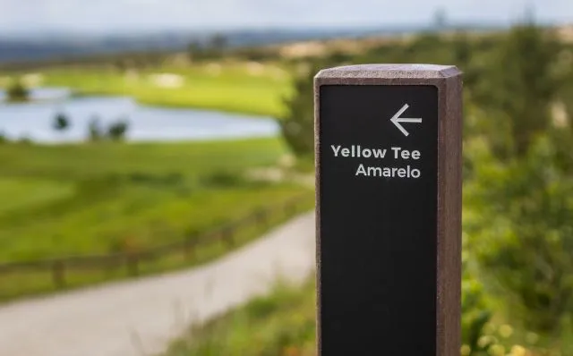 Detalhe de totem direcional royal em plástico reciclado e HPL+. Seta a encaminhar para o Yellow Tee.