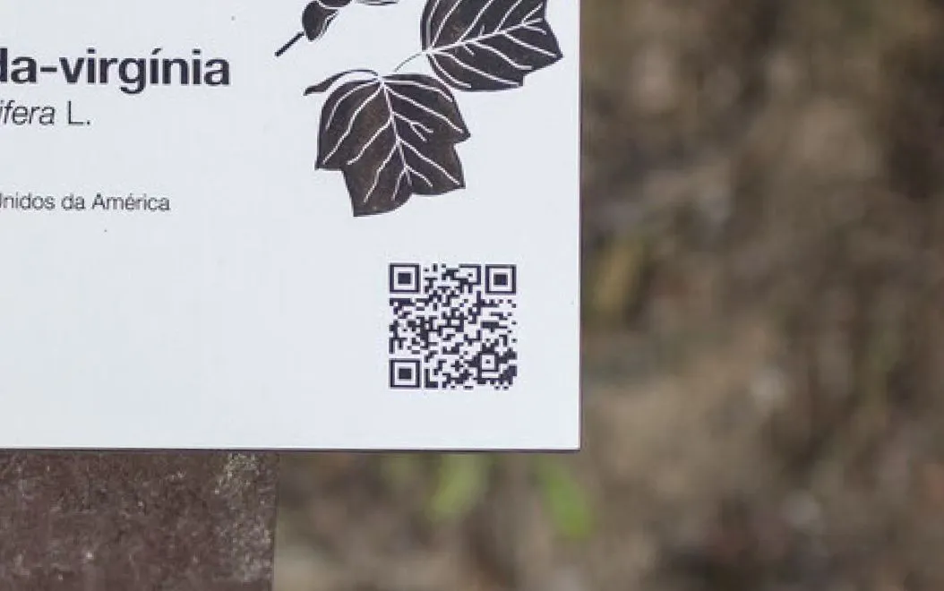 Detalhe de código QR integrado em placa de HPL+ de placa de espécie, modelo Floema, com estrutura em plástico reciclado castanho.