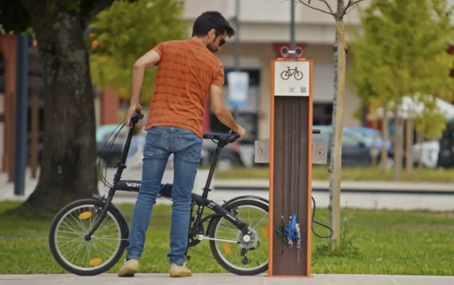 Homem a estacionar bicicleta na Bike Station Charge Plaza da Floema para espaços urbanos.