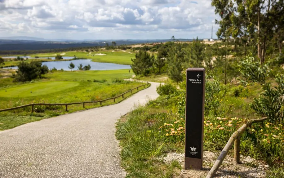 Vista geral de campo com foco no totem direcional royal em plástico reciclado e HPL+ a orientar para o tee amarelo.