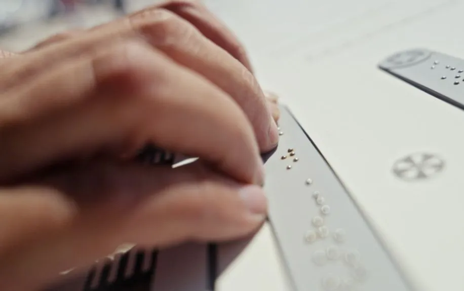 Detalhe do braille na sinalização urbana inclusiva.