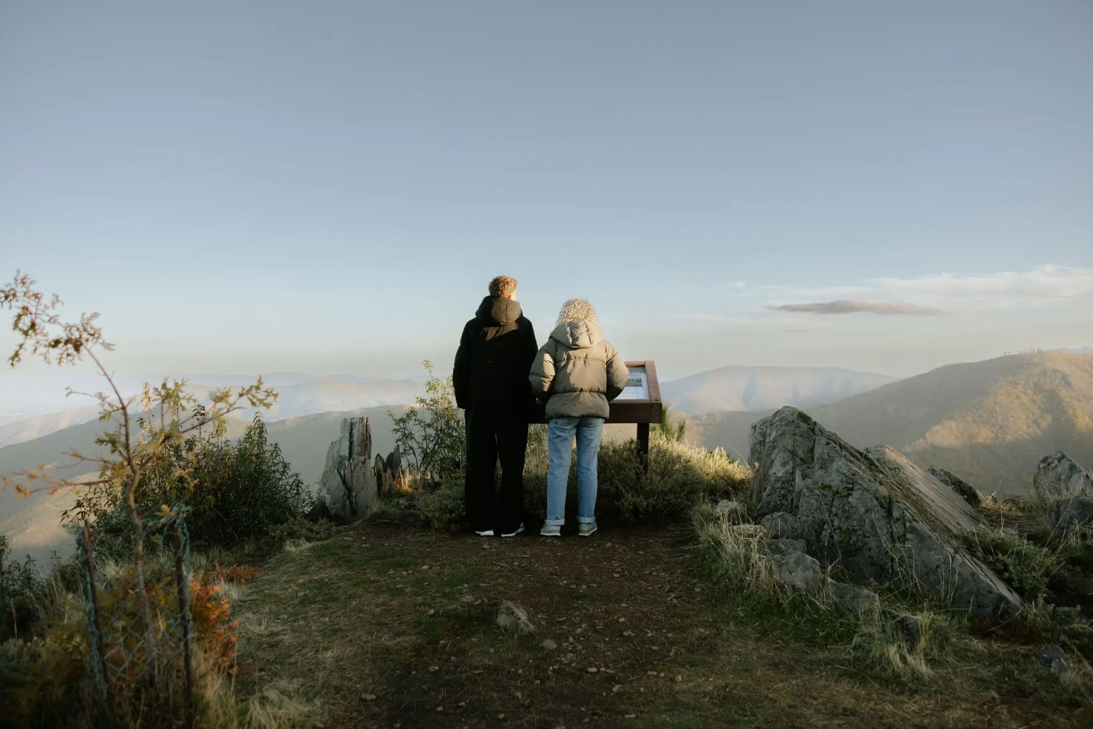 Two people reading content from an ICNF interpretive table, Floema Nature model, in Serra da Estrela.