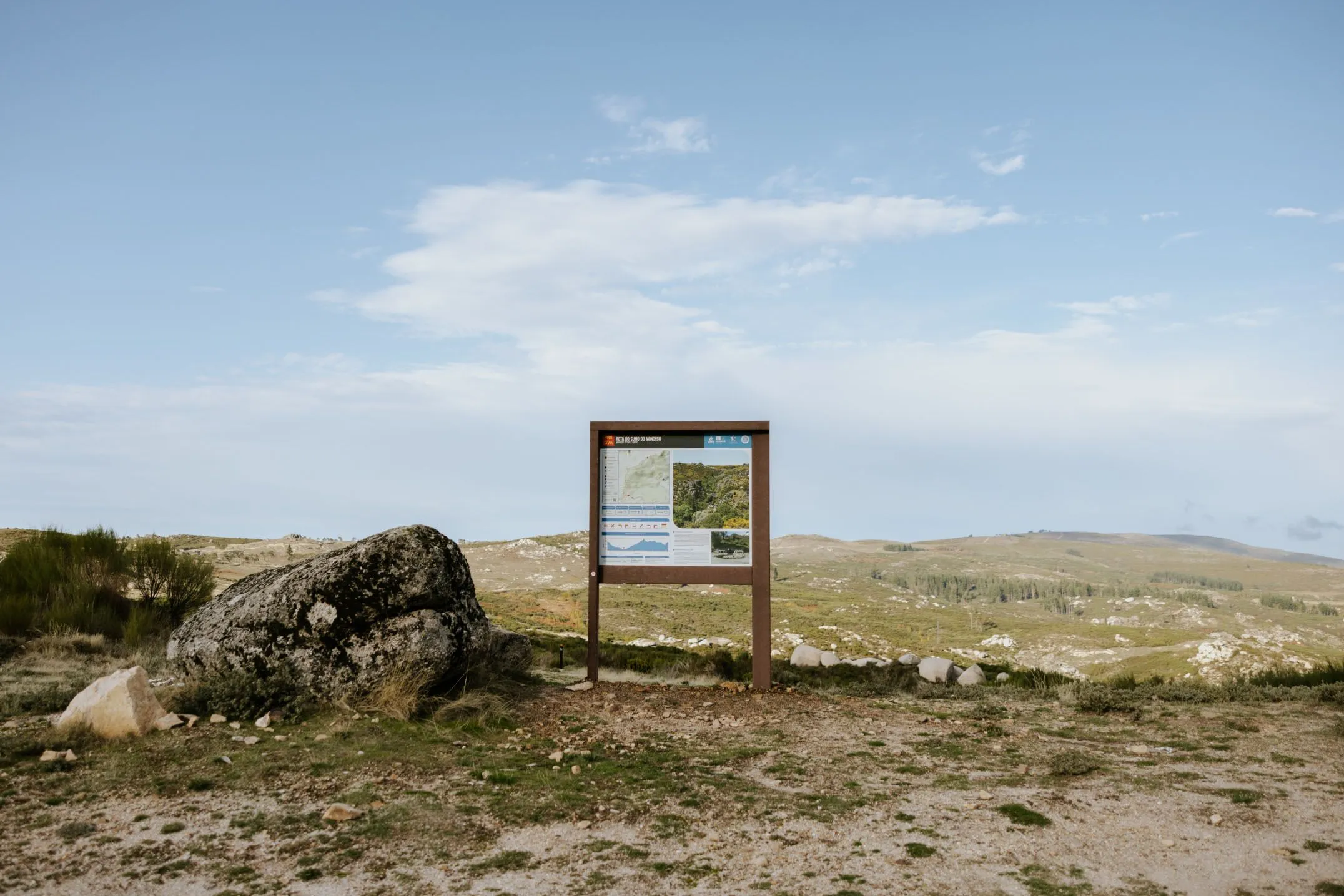 Painel informativo ICNF de plástico reciclado Floema para Geopark Estrela com vista no horizonte da montanha.