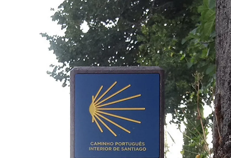 Detalhe de placa em HPL+ de indicação de rota religiosa, caminhos de santiago, integrada em perfil de plástico reciclado castanho Floema. 