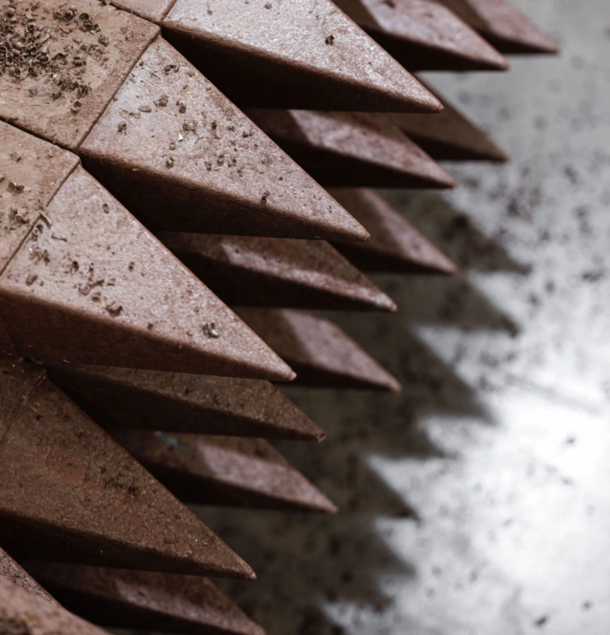 Detalhe de ponta de postes quadrados em plástico reciclado castanho Floema em chão de fábrica.