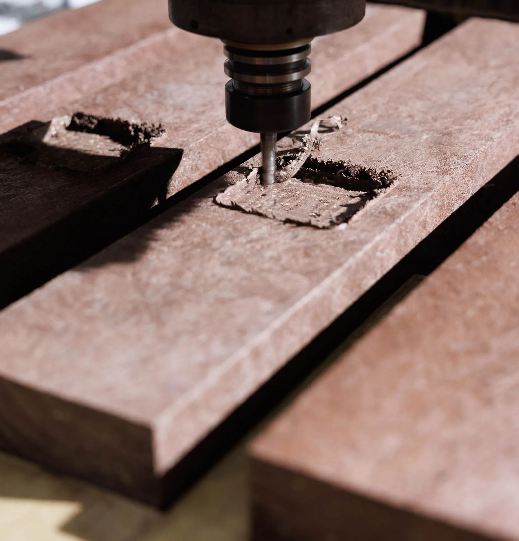 Detalhe de CNC a gravar negativo de baliza para percursos pedestres em plástico reciclado castanho Floema.
