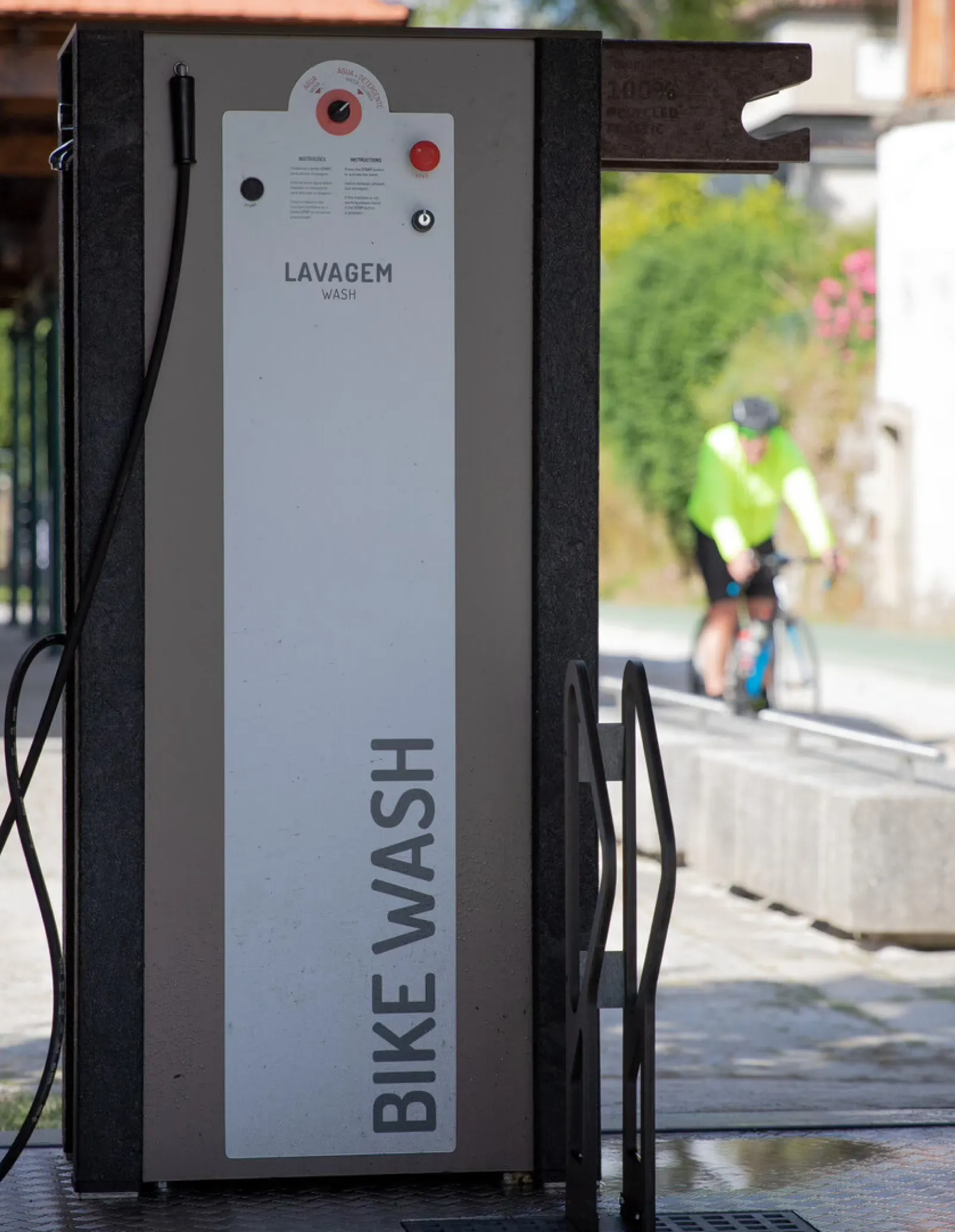 Bike station High Tech Floema personalizada, com estrutura em plástico reciclado preto e HPL+. Vista lateral com sistema de lavagem temporizado e suporte de bicicletas.