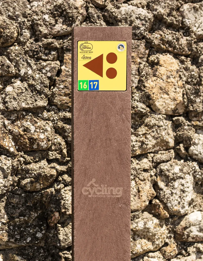 Baliza de Centros Cyclin' Portugal em plástico reciclado, com placa de base embutida, encostada a muro.