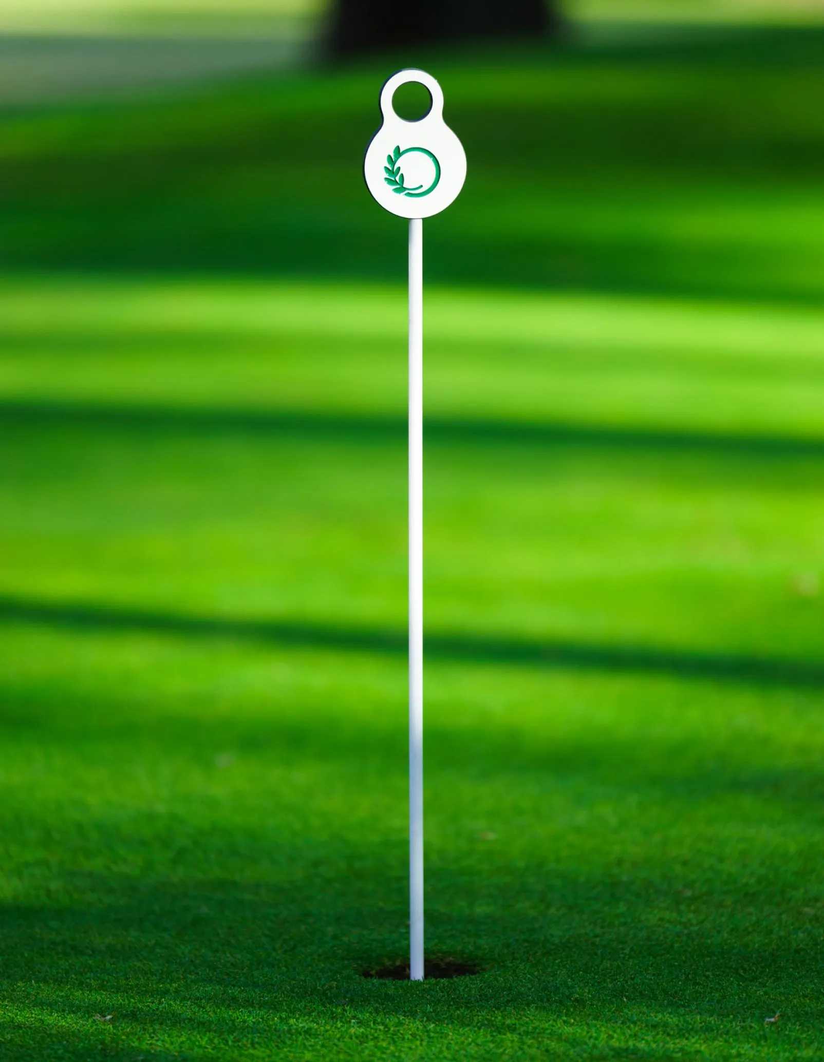 Sinalética de putting green com peça superior com logo gravado em CNC em base de HPL.