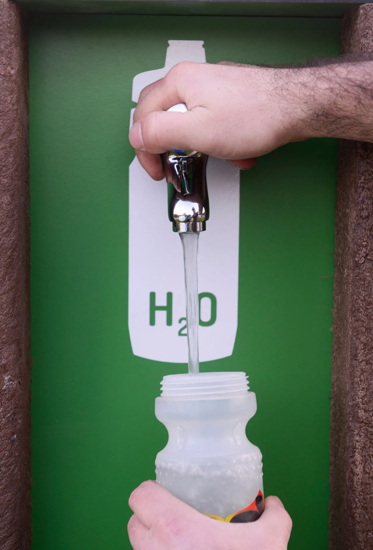 Detalhe de ponto de fornecimento de água de bike station low tech modelo Floema com estrutura em plástico reciclado castanho.