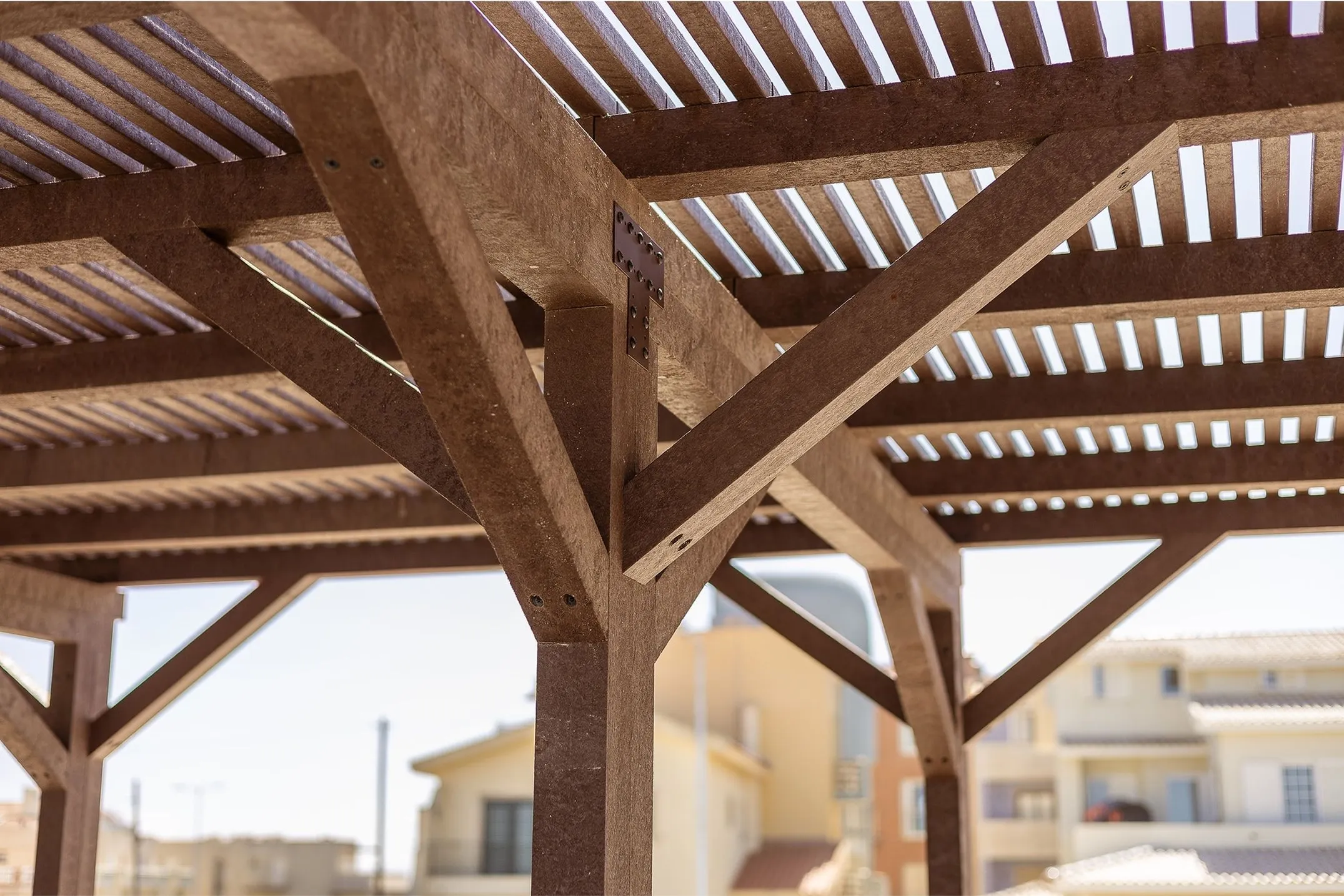 Detalhe de construção de pérgula em plástico reciclado castanho com design Floema
