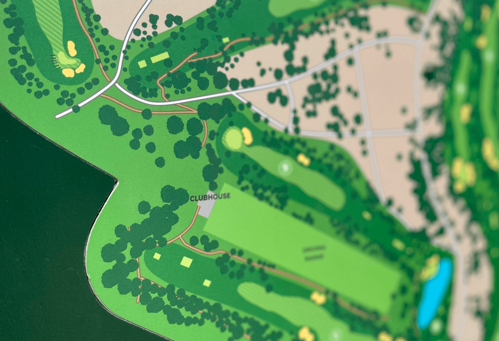 Detalle de placa de aluminio composite con impresión digital de mapa de campo de golf en vinilo polimérico laminado. Placa empotrada en panel de HPL.