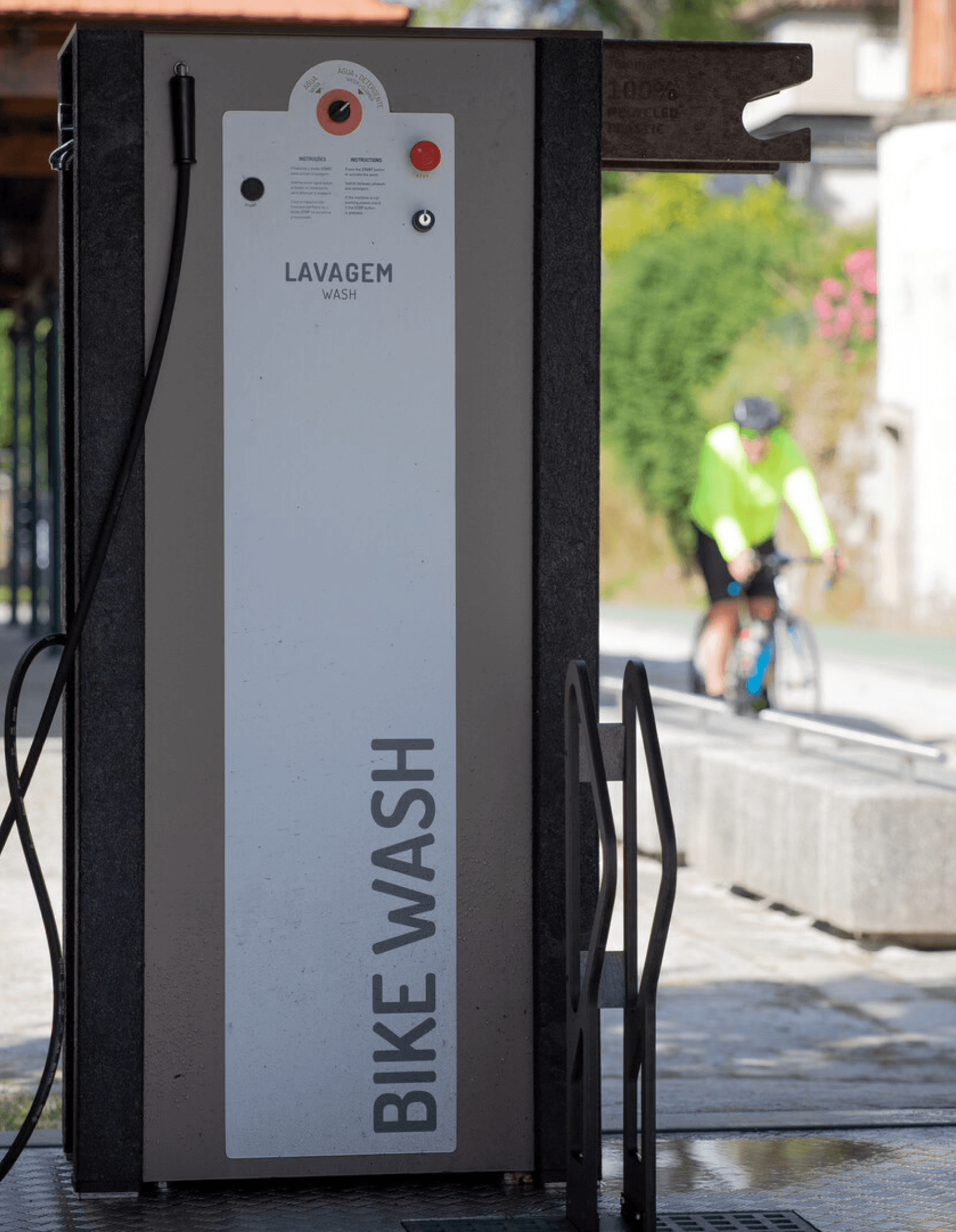 Bike station High Tech Floema personalizada, con estructura en plástico reciclado negro y HPL+. Vista lateral con sistema de lavado temporizado y soporte para bicicletas.