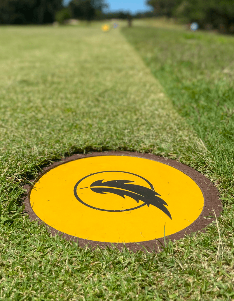 Detalle de disc marker en la zona de salida de un campo de golf.