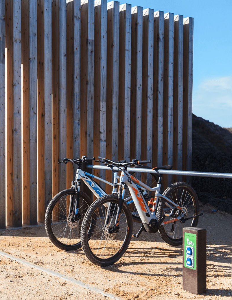 Cargador de e-bike Nature Floema con estructura de plástico reciclado y aparcamiento para bicicletas Triatlo.