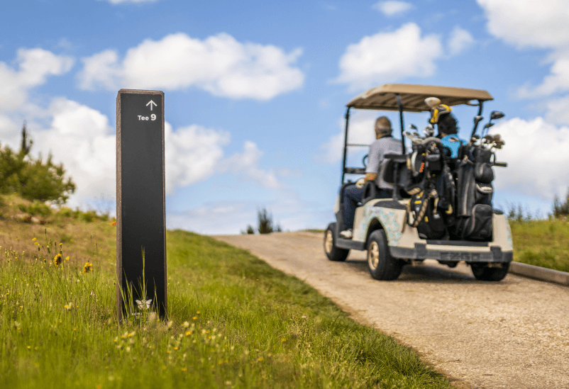 Tótem direccional Royal para campo de golf en plástico reciclado y HPL+. Indicación del recorrido para buggy de golf con bolsas y jugadores.