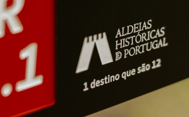 Detalle de grabado del logotipo de Aldeias Históricas de Portugal en placa direccional de recorridos peatonales en HPL+, modelo Floema.