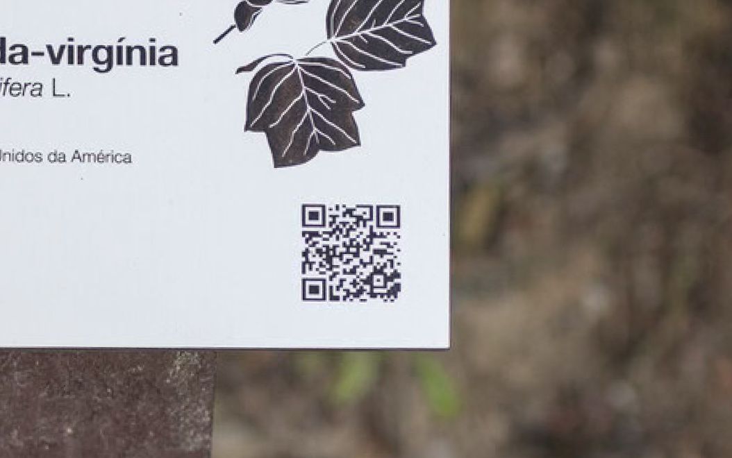 Détail de code QR intégré dans une plaque en HPL+ de panneau d’essence, modèle Floema, avec structure en plastique recyclé brun.