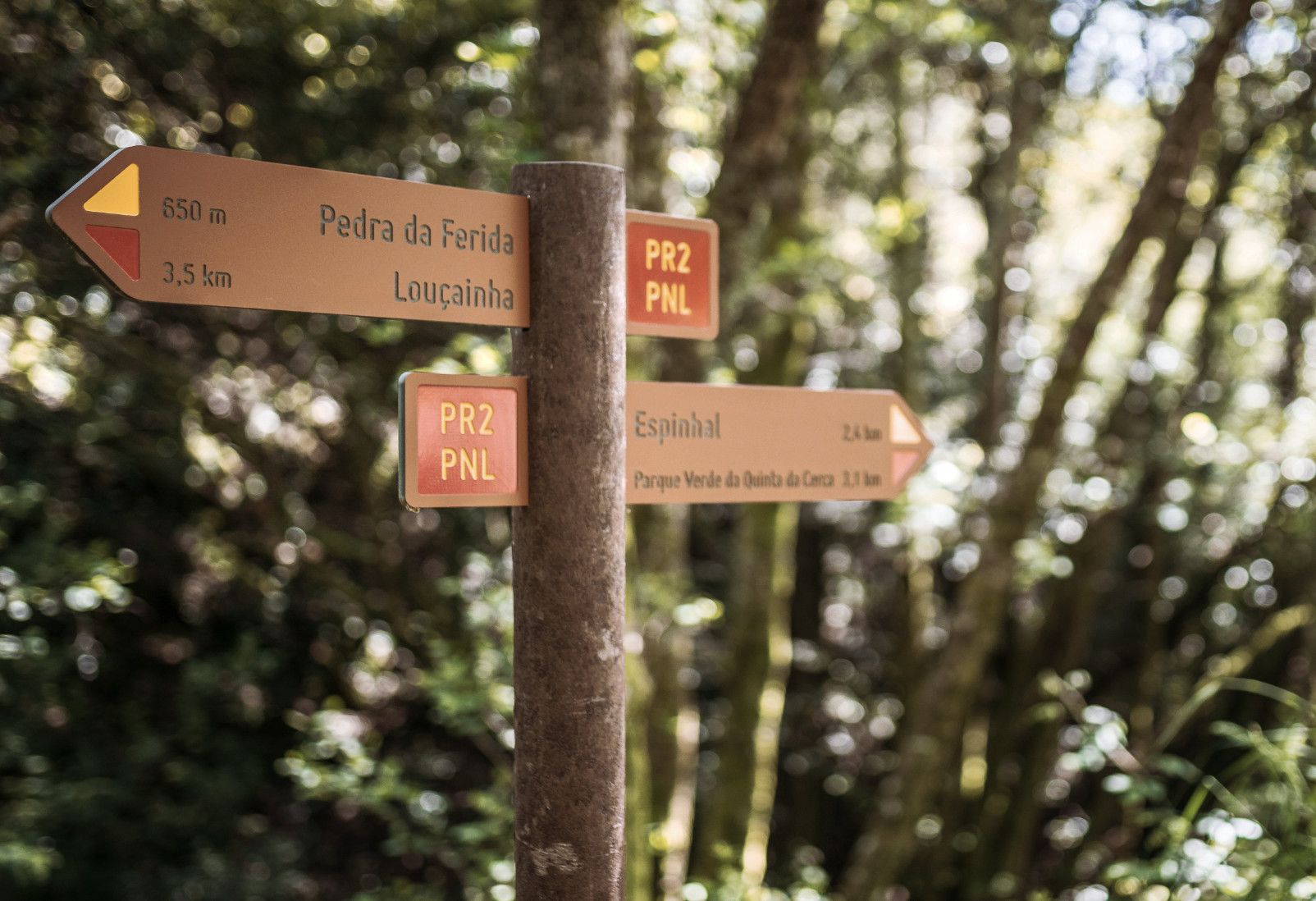 Placas direccionales de recorridos peatonales en HPL+, fijadas a poste de plástico reciclado marrón Floema.