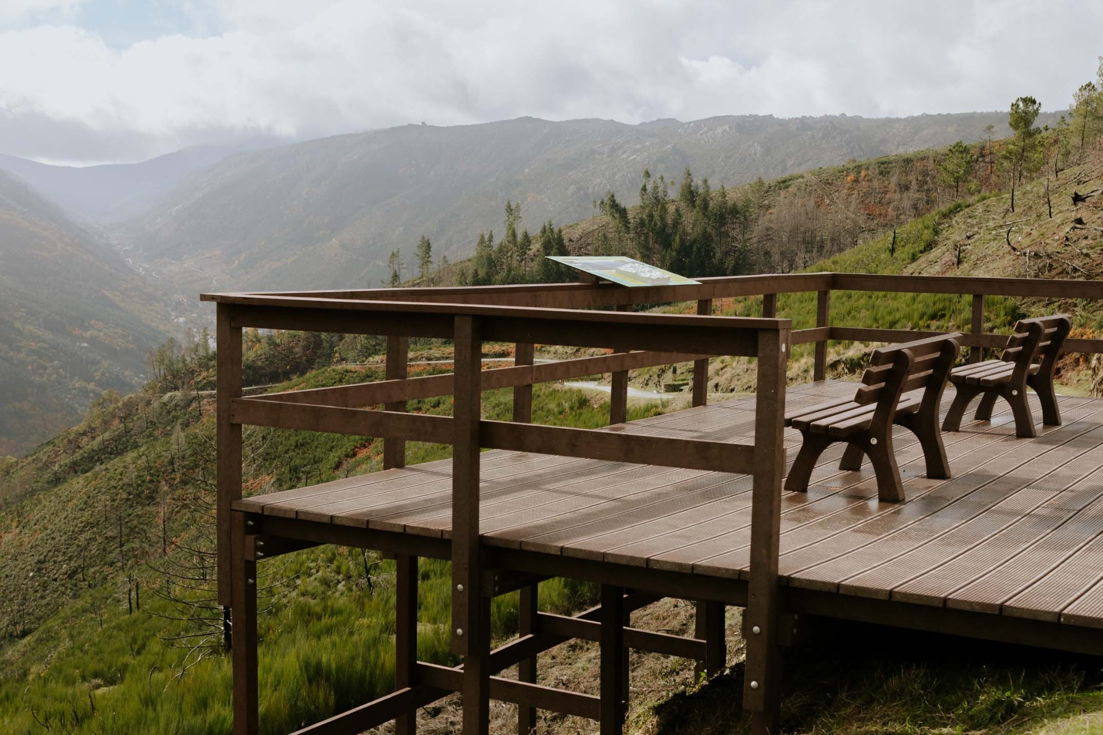 Mirador con bancos de plástico reciclado marrón Floema. Incluye mesa interpretativa modelo Floema en HPL Print. Montañas de la Serra da Estrela al fondo.
